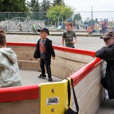 Male Education Assistant kneels down and refs students playing Gaga ball at lunch