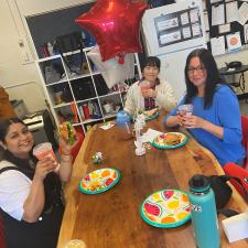 Group of support staff sitting down enjoying starbucks and treats