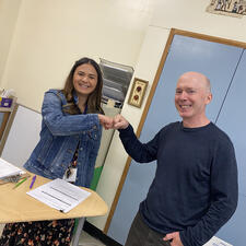 Teacher and student bump fists together.